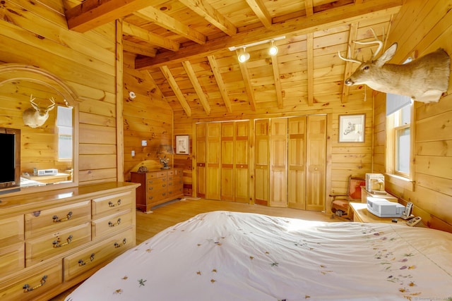 bedroom featuring light wood-style flooring, track lighting, lofted ceiling with beams, wooden walls, and wood ceiling