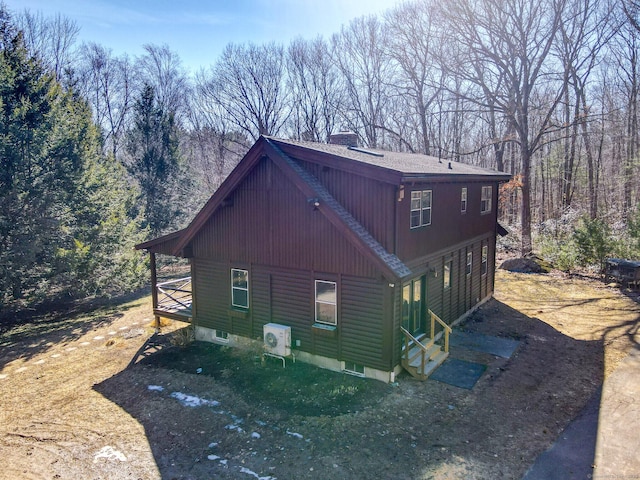 view of side of home featuring roof with shingles and a chimney