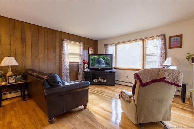 living room featuring light wood-type flooring, wood walls, and a baseboard radiator