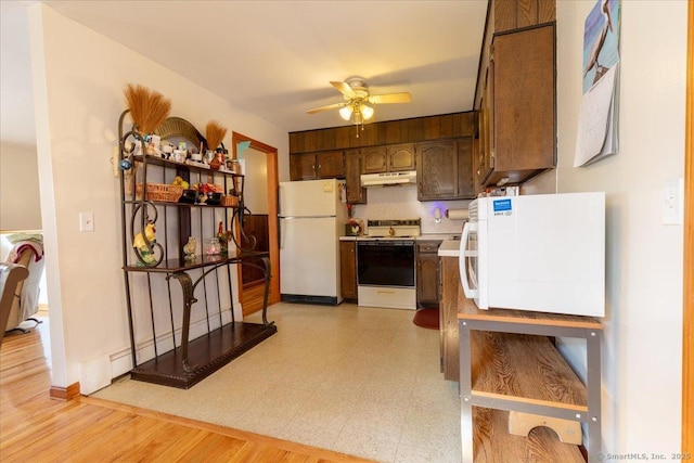 kitchen featuring stove, light floors, refrigerator, freestanding refrigerator, and under cabinet range hood