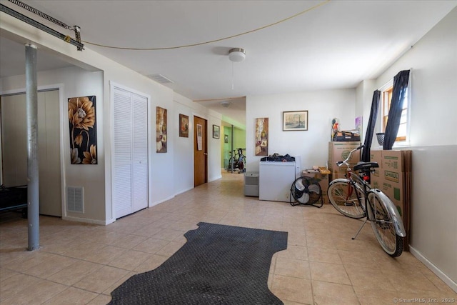 interior space with light tile patterned floors, visible vents, and baseboards