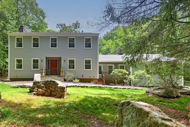 colonial home with a chimney and a front lawn