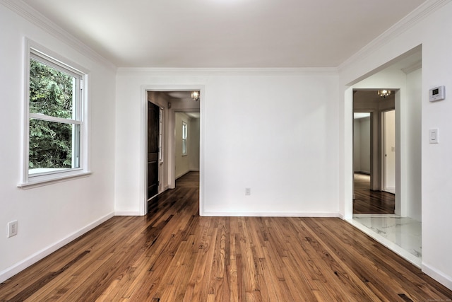 unfurnished room with hardwood / wood-style flooring, baseboards, ornamental molding, and a chandelier