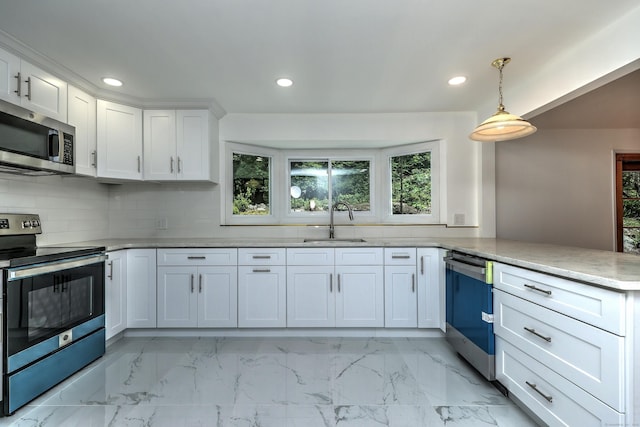 kitchen featuring a peninsula, a sink, white cabinetry, marble finish floor, and appliances with stainless steel finishes