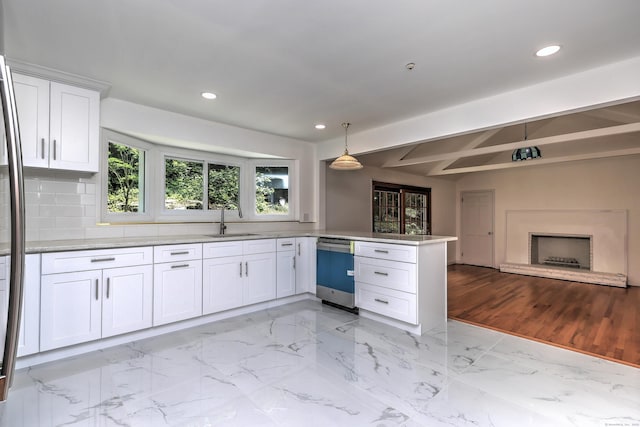 kitchen with marble finish floor, white cabinetry, a sink, dishwasher, and a peninsula