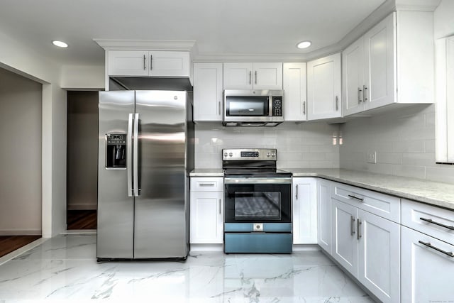 kitchen with marble finish floor, tasteful backsplash, white cabinetry, and stainless steel appliances