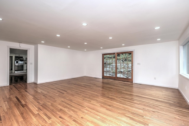 unfurnished living room featuring light wood-type flooring, visible vents, baseboards, and recessed lighting