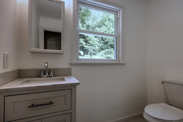 bathroom with vanity, toilet, and baseboards