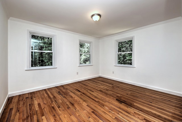 unfurnished room with dark wood-style floors, baseboards, and ornamental molding