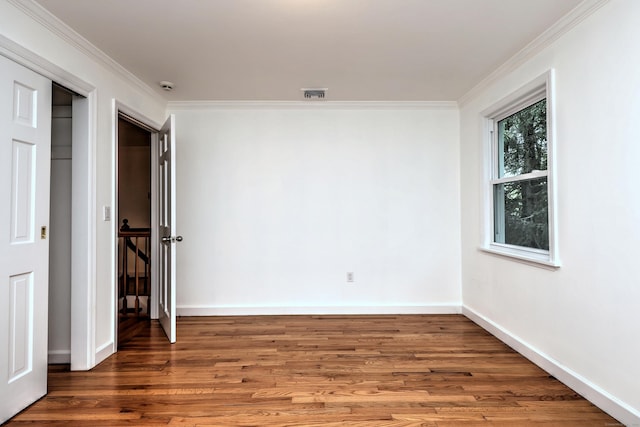 interior space with ornamental molding, wood finished floors, visible vents, and baseboards