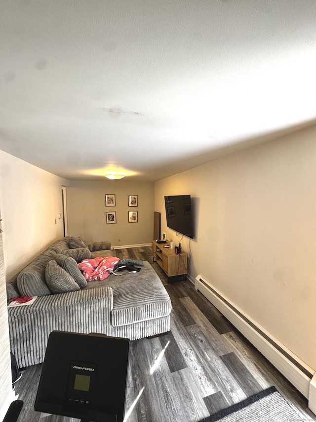 living room with dark wood-style floors and a baseboard heating unit