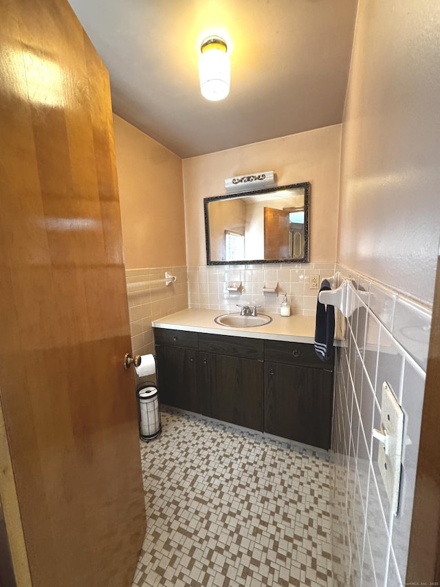 bathroom with wainscoting, tile walls, and vanity