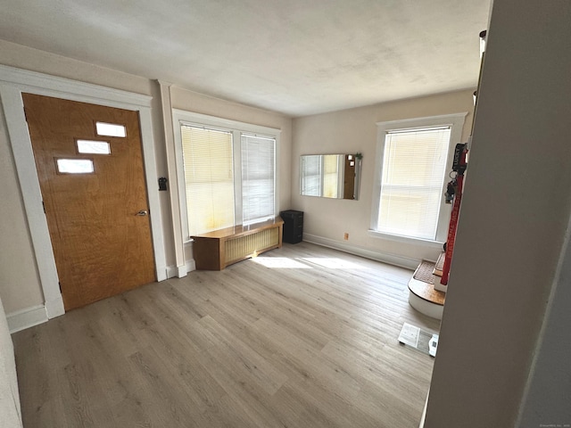entryway with radiator, light wood finished floors, and baseboards