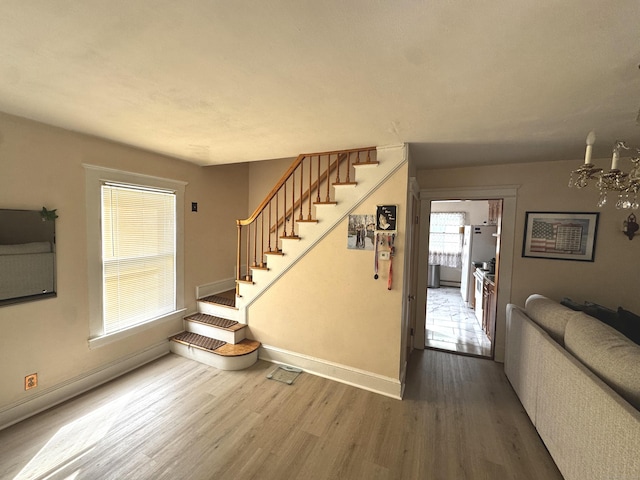 stairs featuring wood finished floors and baseboards