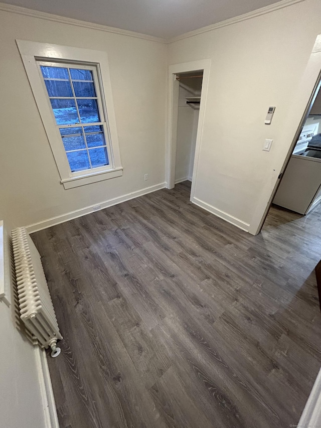 unfurnished bedroom featuring ornamental molding, dark wood-style flooring, a closet, and baseboards