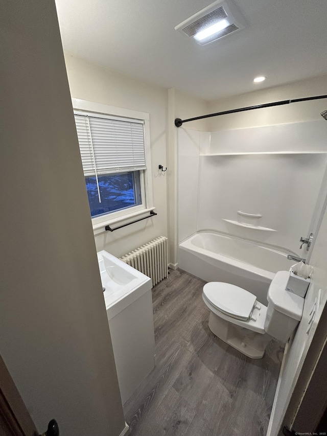 full bath with toilet, wood finished floors, bathing tub / shower combination, visible vents, and radiator