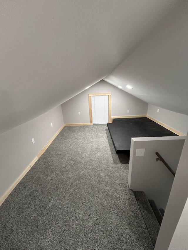 additional living space featuring carpet floors, vaulted ceiling, and baseboards