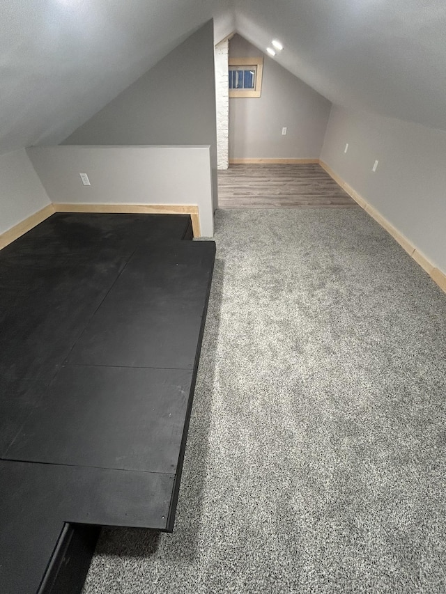 additional living space with vaulted ceiling, carpet floors, and baseboards