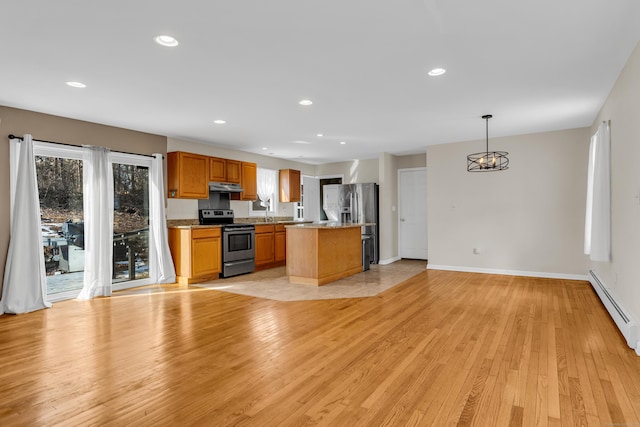 kitchen with recessed lighting, under cabinet range hood, stainless steel appliances, a kitchen island, and light wood finished floors