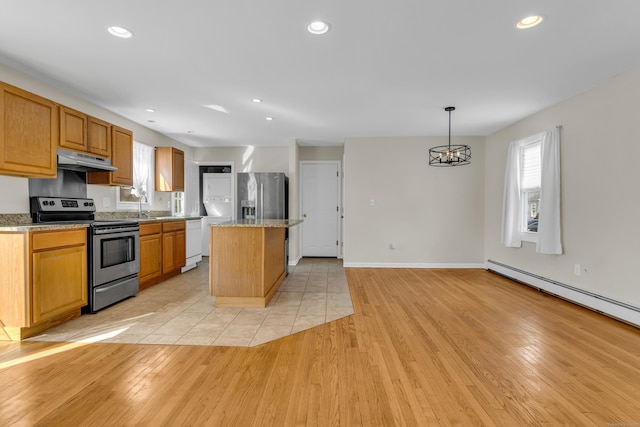 kitchen with a healthy amount of sunlight, under cabinet range hood, appliances with stainless steel finishes, and light wood-style floors