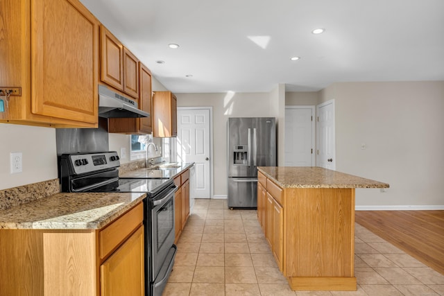 kitchen with a center island, stainless steel appliances, under cabinet range hood, a sink, and light tile patterned flooring