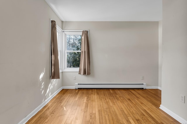 unfurnished room with light wood finished floors, baseboards, and baseboard heating