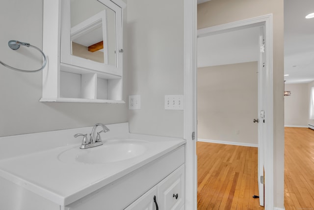 bathroom with vanity, baseboards, and wood finished floors