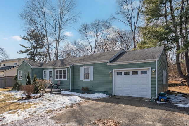 ranch-style house with an attached garage and roof with shingles