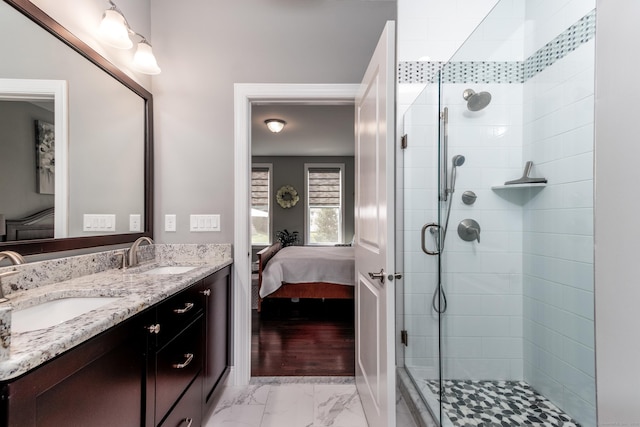 ensuite bathroom with marble finish floor, a shower stall, connected bathroom, and a sink