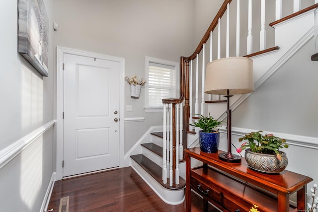 foyer entrance featuring baseboards, stairs, visible vents, and dark wood-type flooring