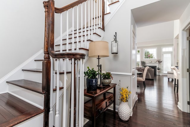 stairway with a fireplace and hardwood / wood-style flooring