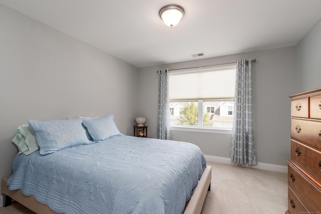 bedroom with visible vents, light carpet, and baseboards