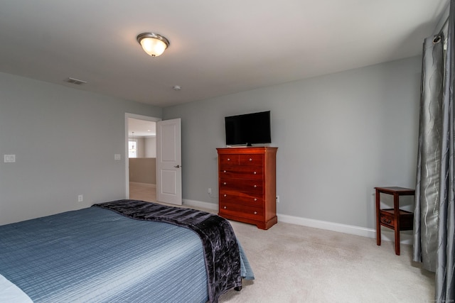 bedroom with baseboards, visible vents, and light colored carpet