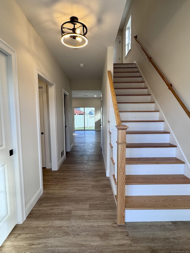 stairs with wood finished floors and baseboards