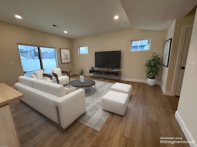 living area with lofted ceiling, plenty of natural light, wood finished floors, and baseboards