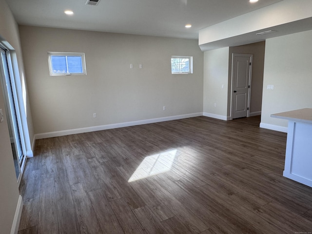 spare room featuring visible vents, baseboards, dark wood-type flooring, and recessed lighting