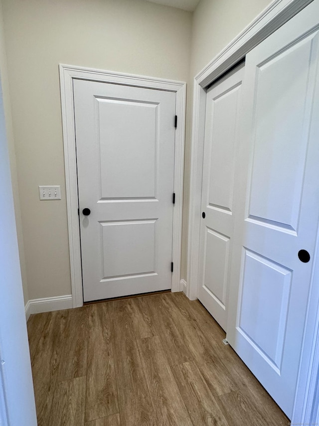 doorway to outside featuring wood finished floors and baseboards