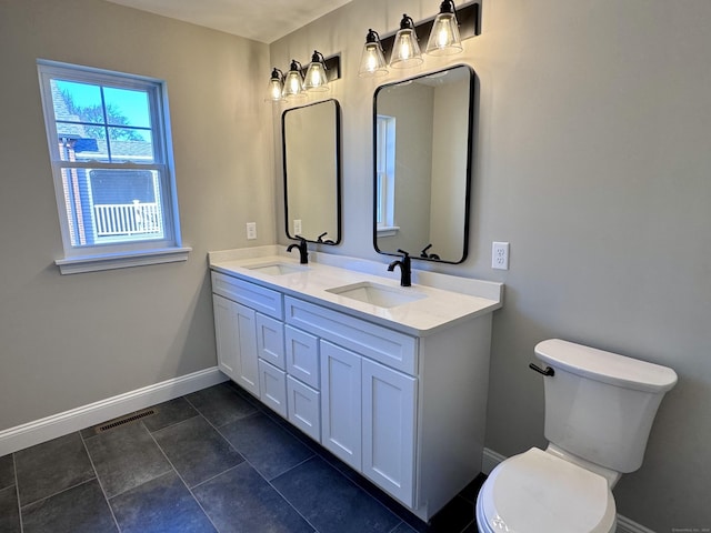 full bath featuring toilet, baseboards, visible vents, and a sink