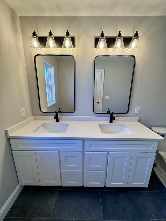 bathroom featuring double vanity, baseboards, toilet, and a sink