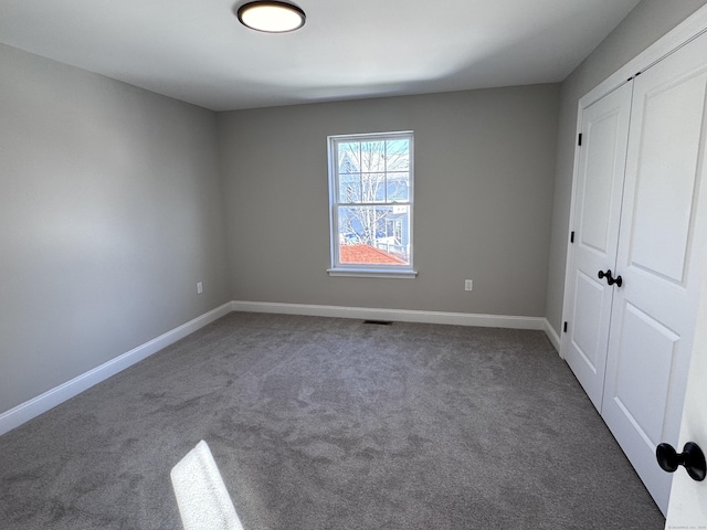 unfurnished bedroom featuring a closet, carpet flooring, visible vents, and baseboards