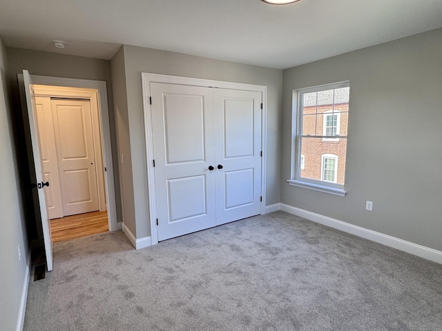 unfurnished bedroom featuring a closet, baseboards, and carpet flooring