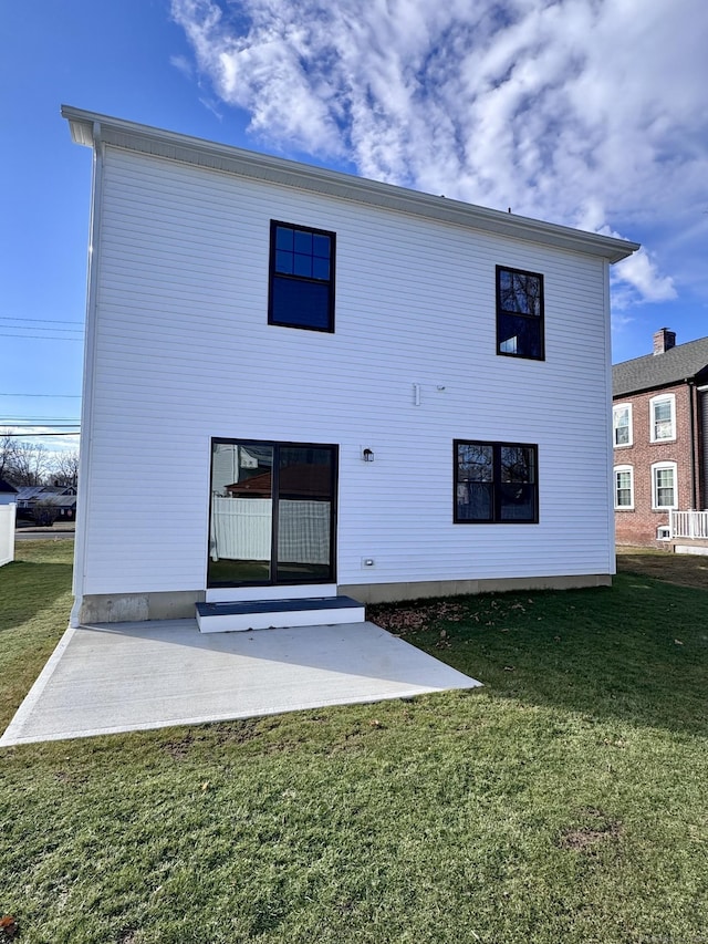 back of house with a patio and a yard