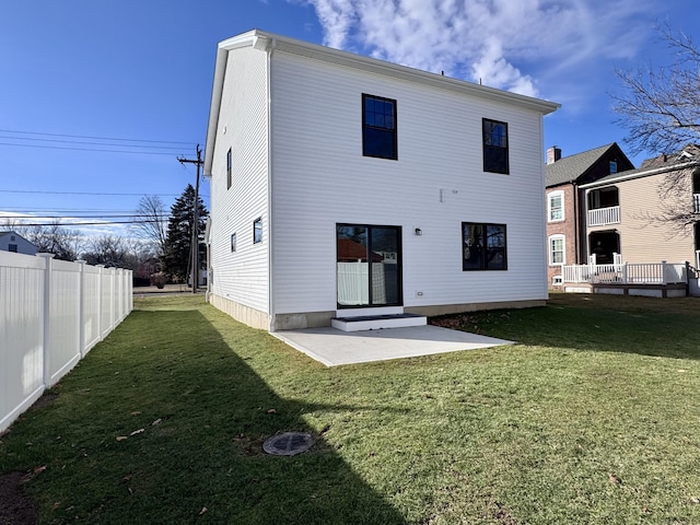 back of property with a patio, a lawn, and fence