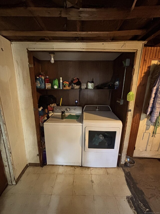 washroom with laundry area, wooden walls, and washer and dryer