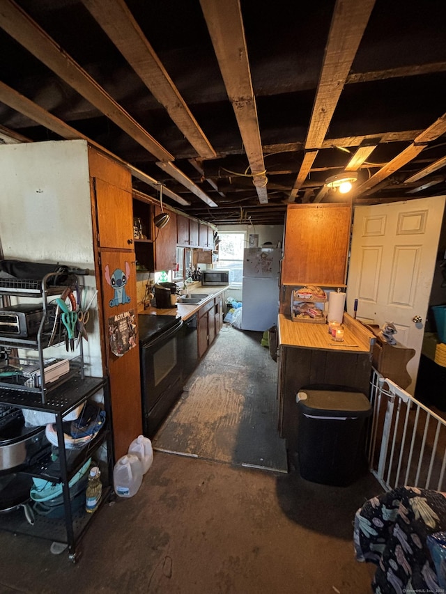 kitchen featuring stainless steel microwave, black range with electric cooktop, a sink, and brown cabinetry