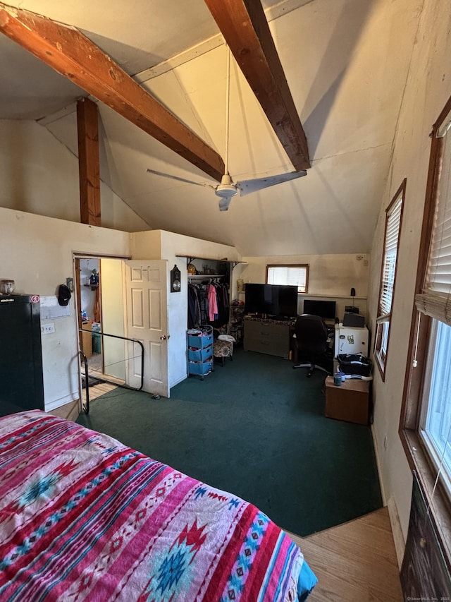 bedroom featuring freestanding refrigerator and vaulted ceiling with beams