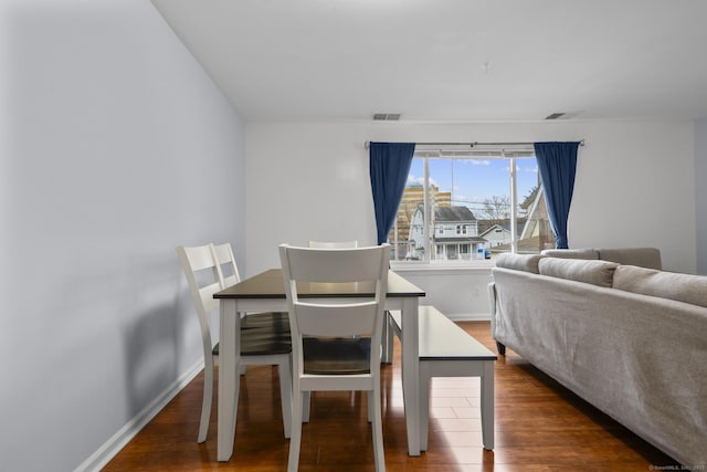 dining space featuring baseboards, visible vents, and wood finished floors