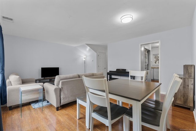 dining space featuring light wood-style flooring and visible vents