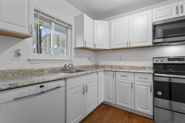 kitchen featuring white cabinets, dark wood-style floors, stainless steel appliances, and a sink