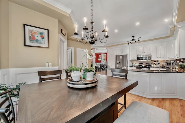 dining area with recessed lighting, ornamental molding, wainscoting, a chandelier, and light wood-type flooring